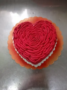 Torta a forma di cuore decorata con rose rosse